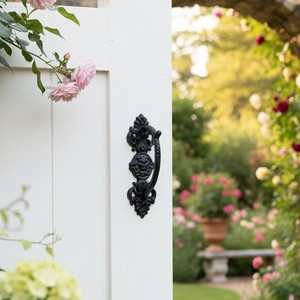 Detail of vintage black cast iron door handle with lion head relief on white wood door