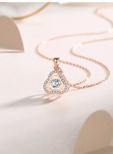 Macro shot of rose gold clover pendant with sparkling moissanite center and pave diamonds