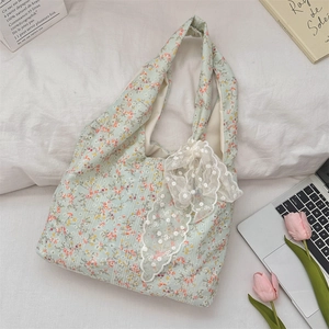 Detailed overhead view of a floral canvas tote bag with white lace trim and daily accessories