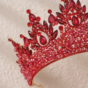 Close-up of luxury bridal crown with red crystals and handcrafted golden beadwork detail