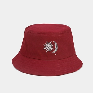 Close-up of wine red cotton bucket hat featuring sun and moon print with woven texture