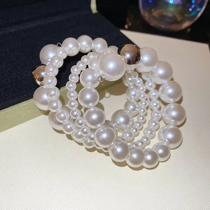 Macro shot of multi-layer pearl bracelet with silver accents and shimmering white texture