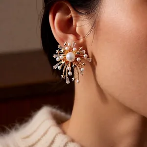 18k gold plated firework stud earrings with zircon and pearls worn on an ear