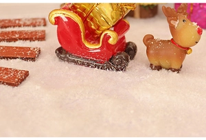 Miniature Christmas sled and reindeer figurine scene with faux snow decor