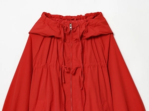 Detailed macro view of bright red nylon jacket featuring adjustable drawstring hood