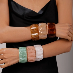Close-up of geometric acrylic bangles with marble texture in multiple colors on model