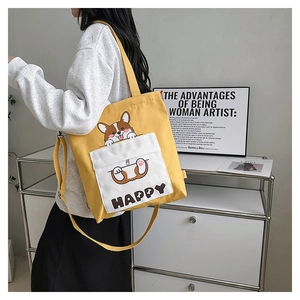 Detail of yellow canvas tote bag with Corgi print and HAPPY text pocket with shoulder strap