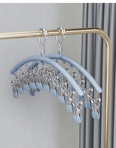 Detail of light blue windproof drying rack with multi-clips on a golden clothes rod