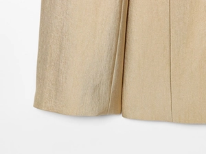 Close-up van de gouden twill stoftextuur en metallic glans op de manchet van de blazer