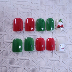 Kurze quadratische Weihnachtsnägel mit roten, grünen und festlichen Gnome-Mustern