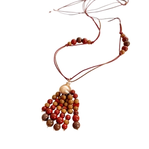 Vintage ethnic necklace with red and brown wooden beads tassels and golden metal accents