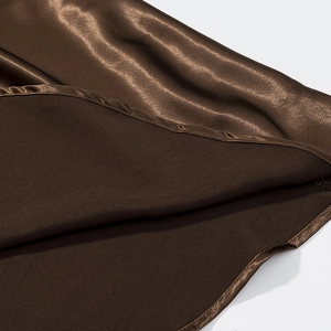 Macro detail of high-quality brown satin fabric with smooth texture and fine stitching