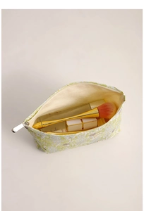 Detailed top view of open floral cosmetic bag with zipper and soft fabric lining