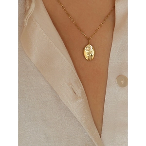 Detailed view of rose flower embossed oval pendant on a gold stainless steel chain