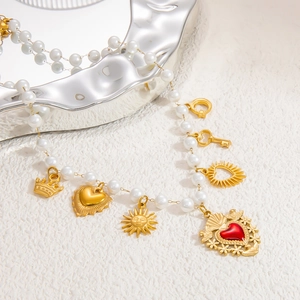 Detailed close-up of pearl necklace with vintage gold heart and crown charms