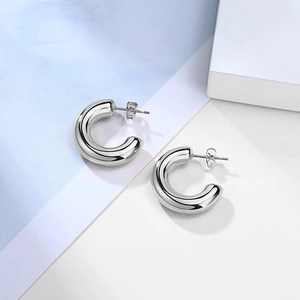 Detailed close-up of silver hollow C-shaped hoop earrings with polished mirror finish
