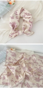 Detail of beige square scarf with red floral pattern shown tied and laid flat