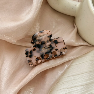 Detail of French vintage acetate hair claw with leopard pattern and gold lettering