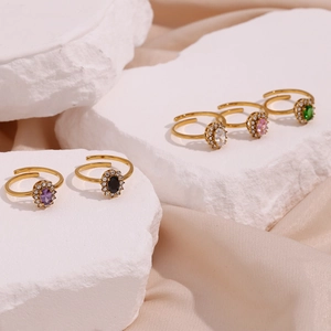 Detail of adjustable 18K gold plated rings featuring oval gemstones and zircon halos