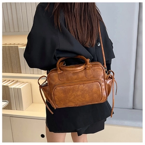 Rear view of a vintage brown leather backpack worn by a model in a minimalist setting