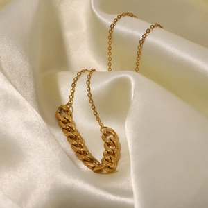Collier double chaîne dorée avec maillons cubains et croix sur tissu en soie beige