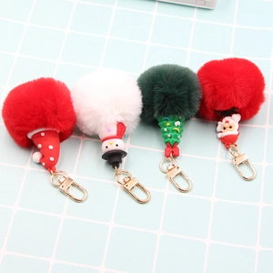 Detail of four Christmas pompom keychains featuring Santa, Snowman and festive trees