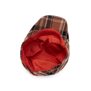 Detail view of plaid flat cap with brown checkered wool and vibrant orange lining