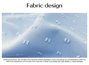 Macro view of light blue fabric with textured polka dots and clear washing instructions