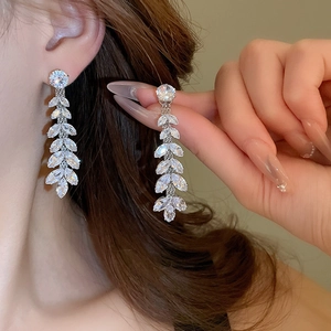 Elegant silver wheat leaf tassel earrings with zircon crystals shown on a model