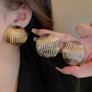 Chunky metal textured round earrings with vertical stripe pattern in gold and silver