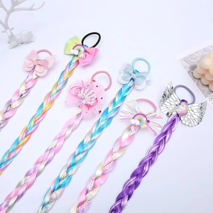 Vue détaillée d'élastiques licorne avec papillons pailletés et tresses arc-en-ciel