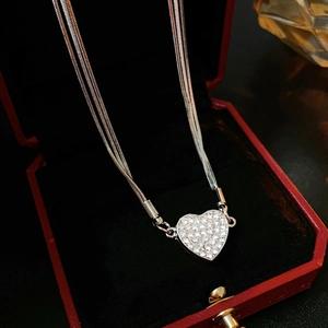 Macro view of a tiered snake chain necklace with a sparkling heart pendant in a red box