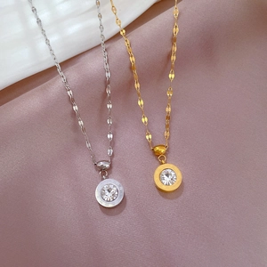 Macro shot of gold and silver Roman numeral necklaces with zircons on pink silk
