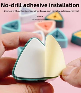 Detail of the adhesive backing removal for a triangular wall-mounted towel holder