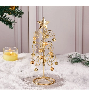 Close-up of golden metal wire Christmas tree with small bells on artificial snow