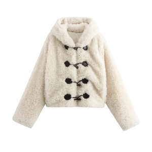 Detail of white faux fur coat featuring black toggle closures and soft hooded texture