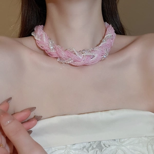 Close-up of pink and white multi-strand beaded necklace with bow lace and pearls