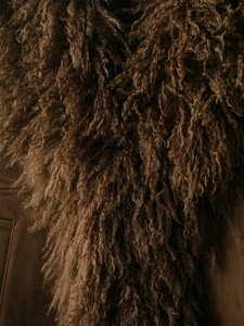 Macro detail of dark brown faux fur and suede texture on a stylish winter jacket