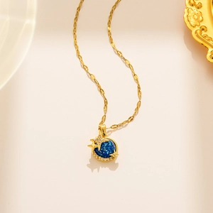 Collier en acier titane avec pendentif planète bleue et étoiles dorées sur beige