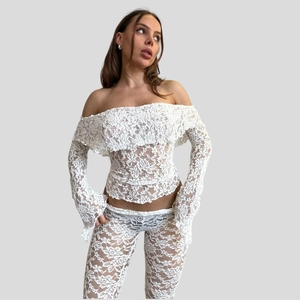 Elegant white lace two-piece set featuring off-shoulder long sleeve top and flared trousers