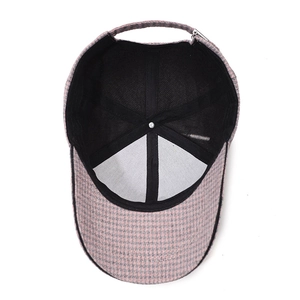 Inside view of pink and grey houndstooth baseball cap with adjustable metal buckle strap