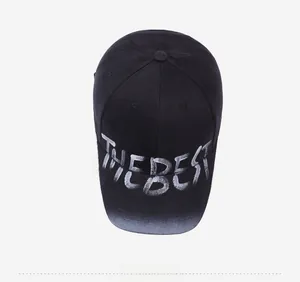 Top view of a black washed baseball cap with white THE BEST graffiti lettering