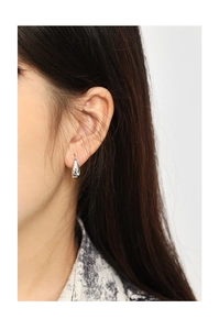 Close-up of elegant polished silver water-drop earring worn by a model in a minimalist style