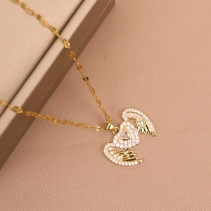 Elegant gold heart wings necklace with sparkling cubic zirconia on a warm gift background