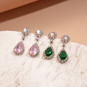 Elegant vintage pear-cut zircon earrings set in pink and green hues with a marble base