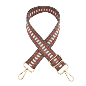Detail of colorful woven wide bag strap with gold metal hardware and thick texture