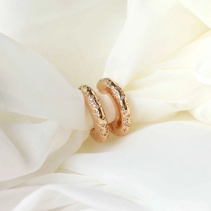 Elegant gold C-shaped star and moon earrings with cubic zirconia on soft white fabric