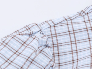 Detail of blue and brown checkered fabric with high-quality stitching on mini dress