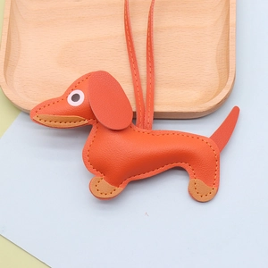 Close-up of bright orange dachshund leather pendant with detailed stitching and lychee texture