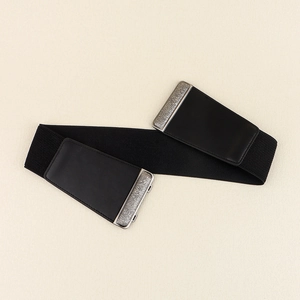 Close-up of black elastic waist belt with vintage matte buckle and silver relief texture